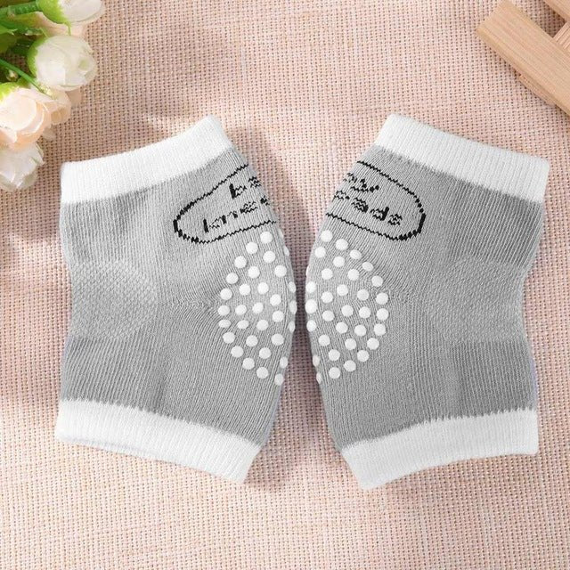 Grey polka dot baby safety knee pads for cushioned crawling practice on tiles, laminate, and wooden floors.
