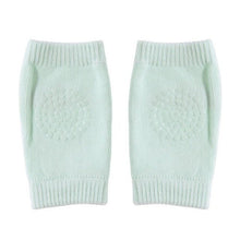 Light green knitted baby knee pads with thick padding for extra protection on hard indoor surfaces.