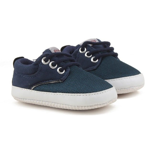 Pair of navy blue baby shoes with white soles 