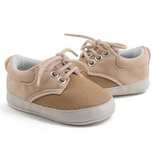 Pair of beige baby sneakers with white soles 