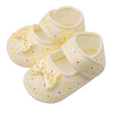Pair of yellow baby shoes with a bow 