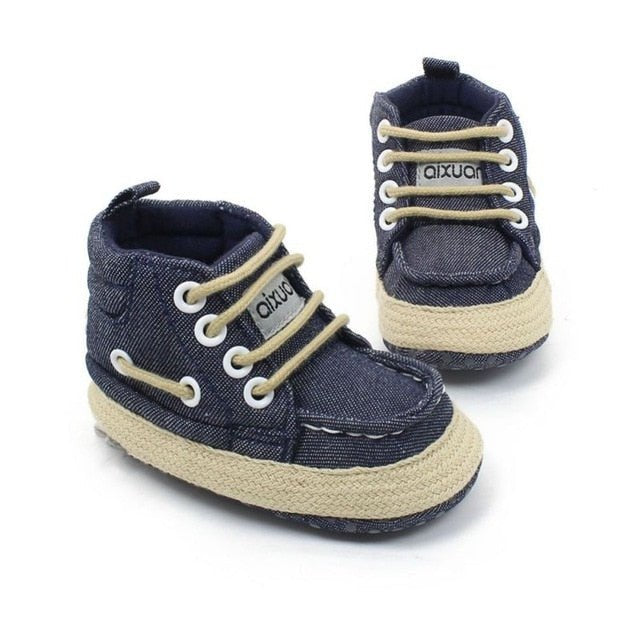 Pair of navy blue baby shoes with beige soles