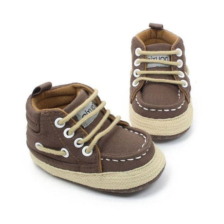 Pair of brown baby shoes with white laces 