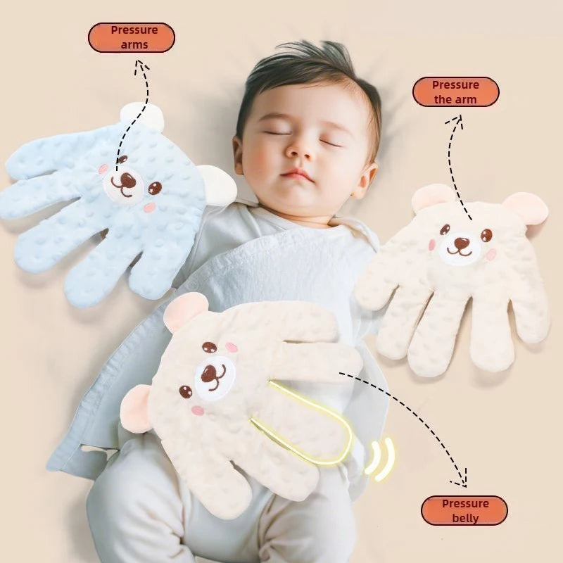 Blue and cream bear-face palm pillows shown beside a sleeping baby
