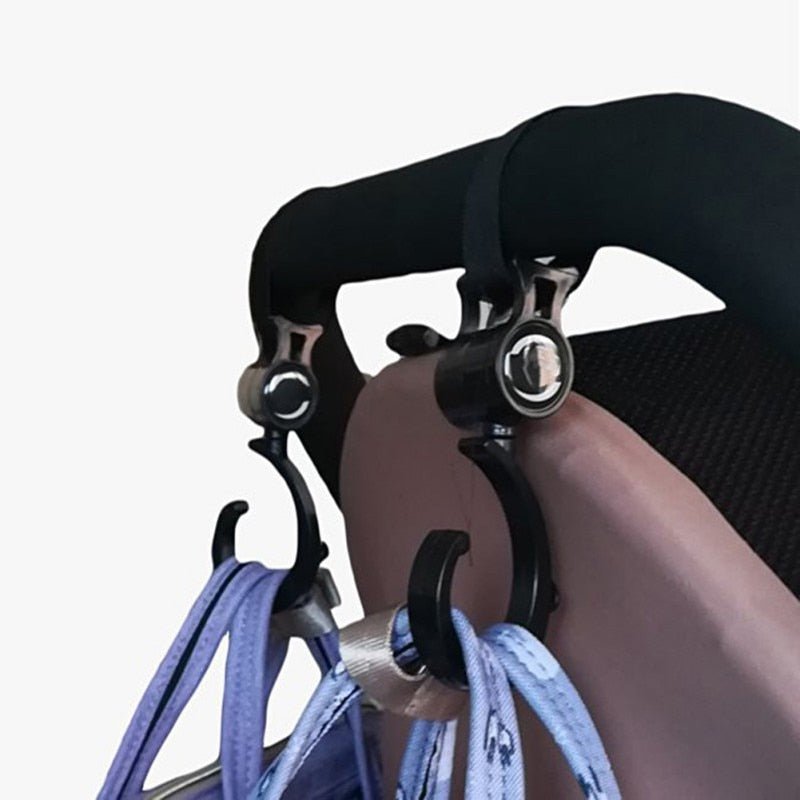 2PCS Baby Hanger Stroller Hooks with black clip-on straps for hanging diaper bags and shopping totes on pram handles during walks.