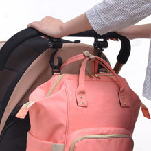 Baby Bag Stroller Hooks holding a pink backpack on a pram handle for hands-free carrying on daily walks and errands.
