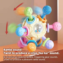 Cream teether rattle ball with arrows showing the twisting motion that makes a ka-ka sound