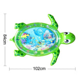 Green turtle-shaped inflatable play mat with underwater scene and measurements.