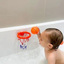 Baby playing with the whale bath basketball set in the tub for splashy bath time fun.