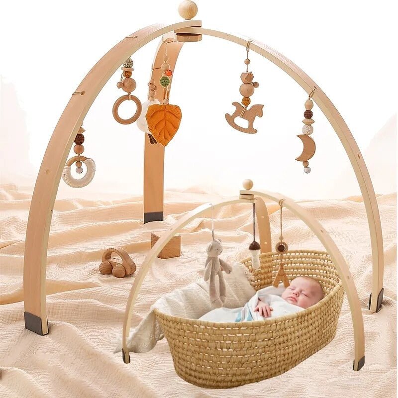 Baby Wooden Play Gym with hanging sensory mobile toys arched over a basket for supervised tummy time play.