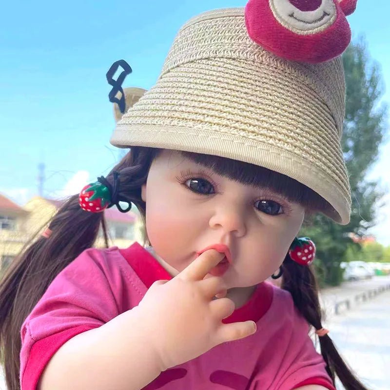 Bathable silicone Reborn Doll with curly hair in a straw hat and pink bow for outdoor play, photo styling, and bath time.