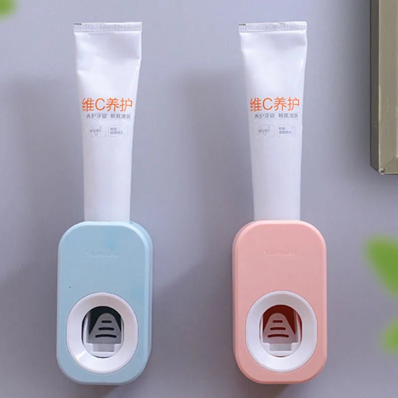 Two toothpaste holders, one blue and one pink, with toothpaste tubes on a gray background.