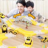 Toy construction set with tracks and vehicles on a wooden surface, featuring a man and child interacting.