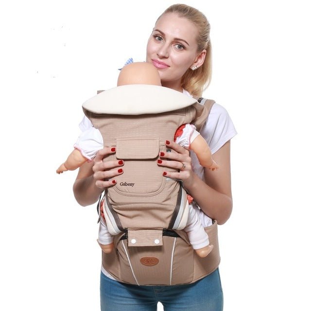 Woman holding a baby in a beige baby carrier