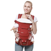 A woman using a red baby carrier 