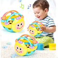 Child playing with yellow bee-face rattle ball teether toys