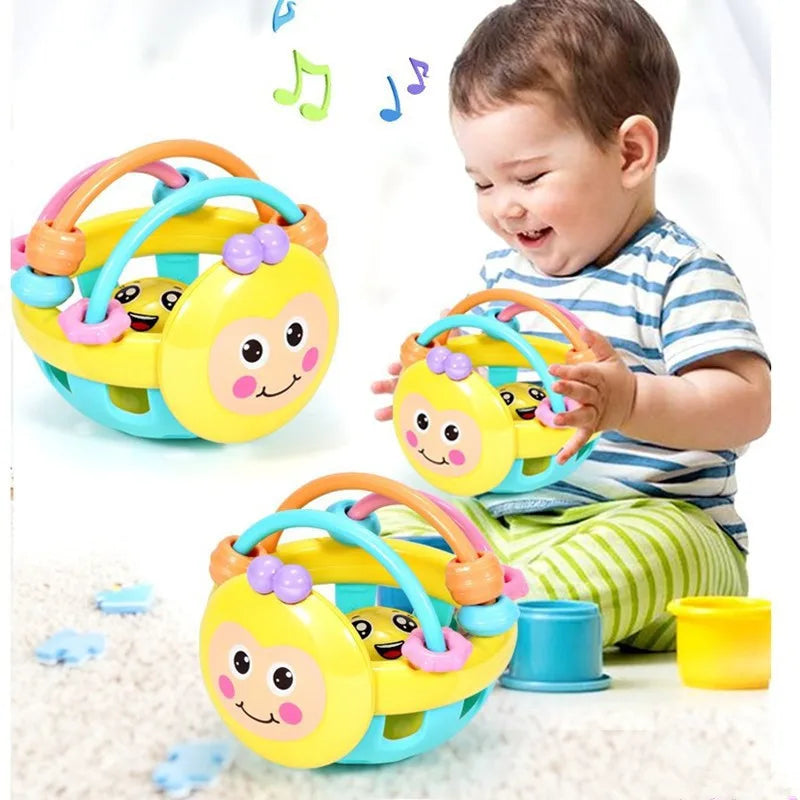 Child playing with yellow bee-face rattle ball teether toys