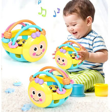 Child playing with yellow bee-face rattle ball teether toys