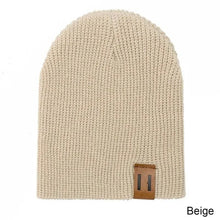 Beige knitted baby hat with leather patch as a crochet beanie for newborn warmth and daily winter wear.