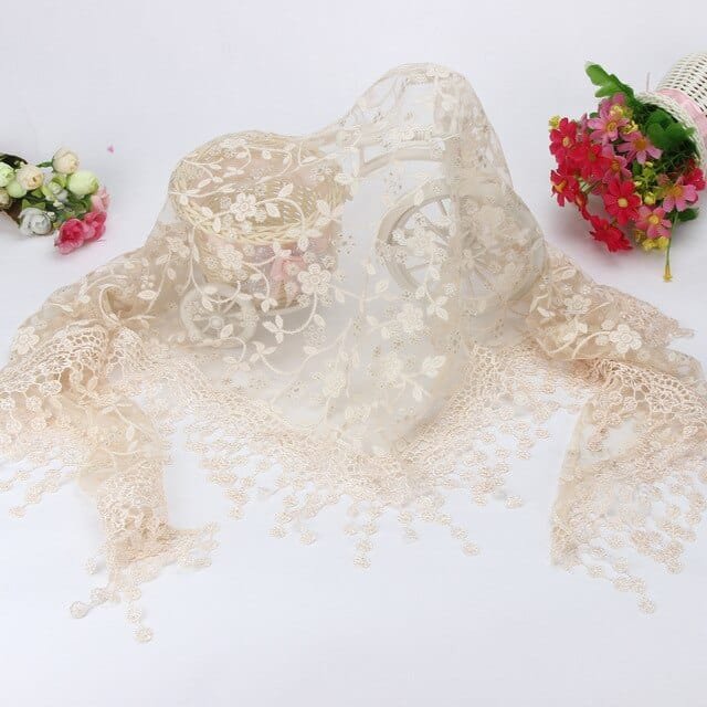 Beige lace baby wrap flat lay as a newborn prop for neutral-toned photography and nursery keepsakes.