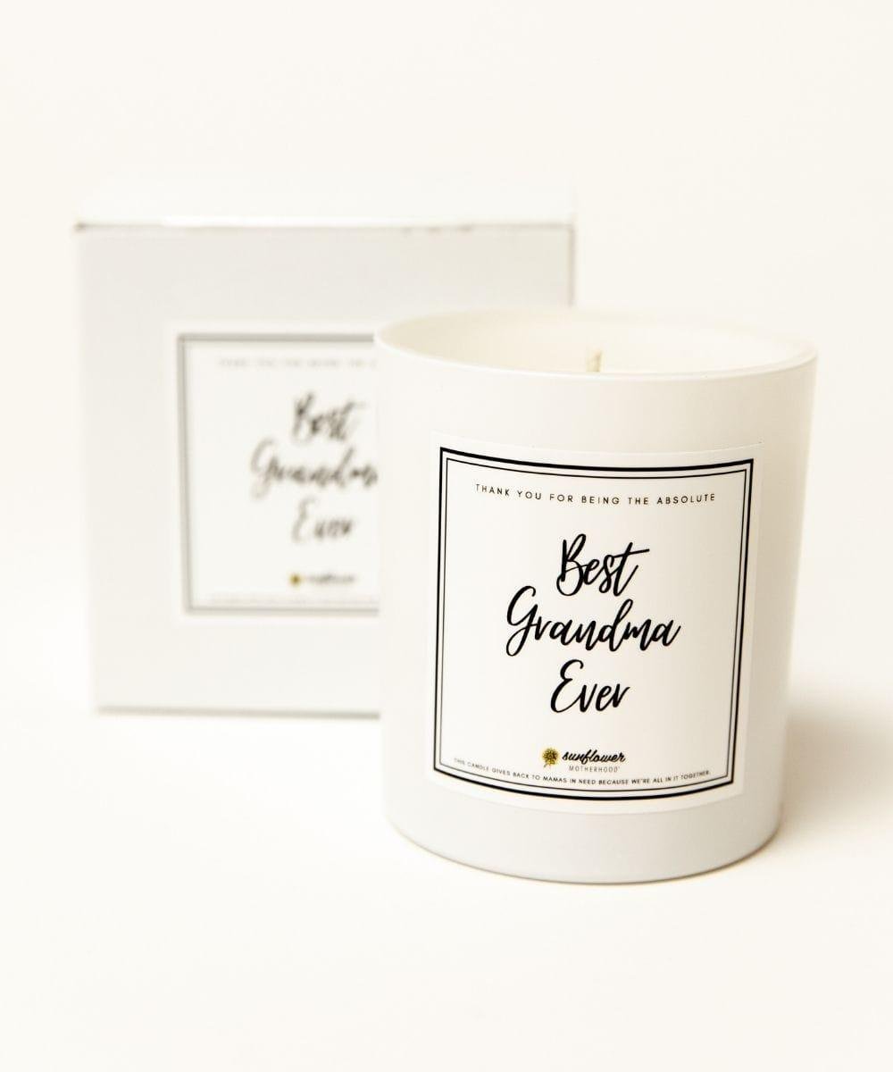 White candle with 'Best Grandma Ever' label next to a framed picture 