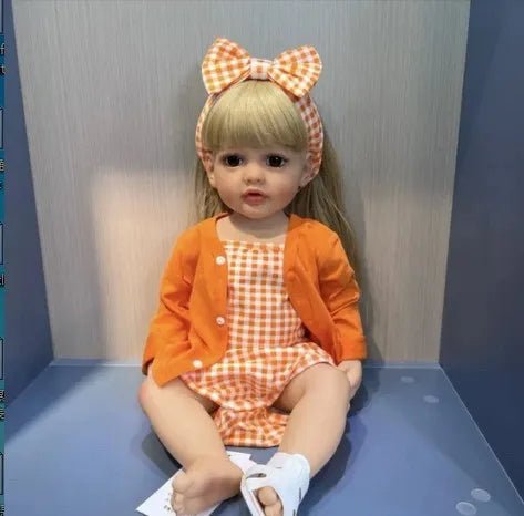 Betty Princess full silicone Reborn Doll in an orange outfit sitting for playroom display, posing, and doll collecting.