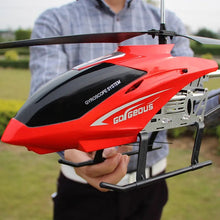 Red and black toy helicopter with 'Gorgeous' branding held by a person outdoors.