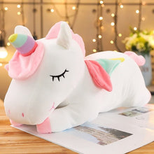 Plush unicorn toy on a wooden surface