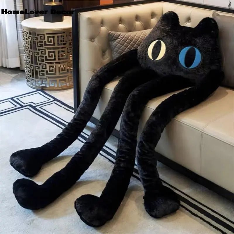 Black cat-shaped plush ball pillow resting on a white couch for cozy seating comfort.