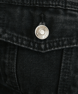 Close-up of a black denim jacket with a button and brand logo.