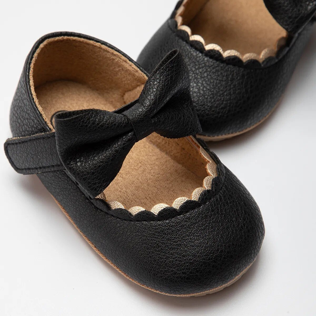 Black infant bow Mary Jane shoes with grip rubber sole for secure toddler walking.