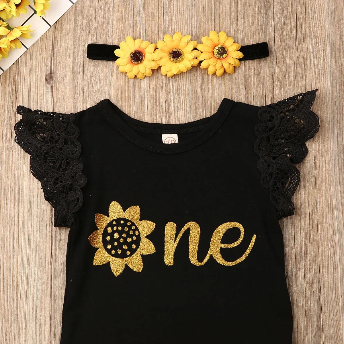 Black sunflower onesie with one text and matching headband for baby girl first birthday cake smash sessions.