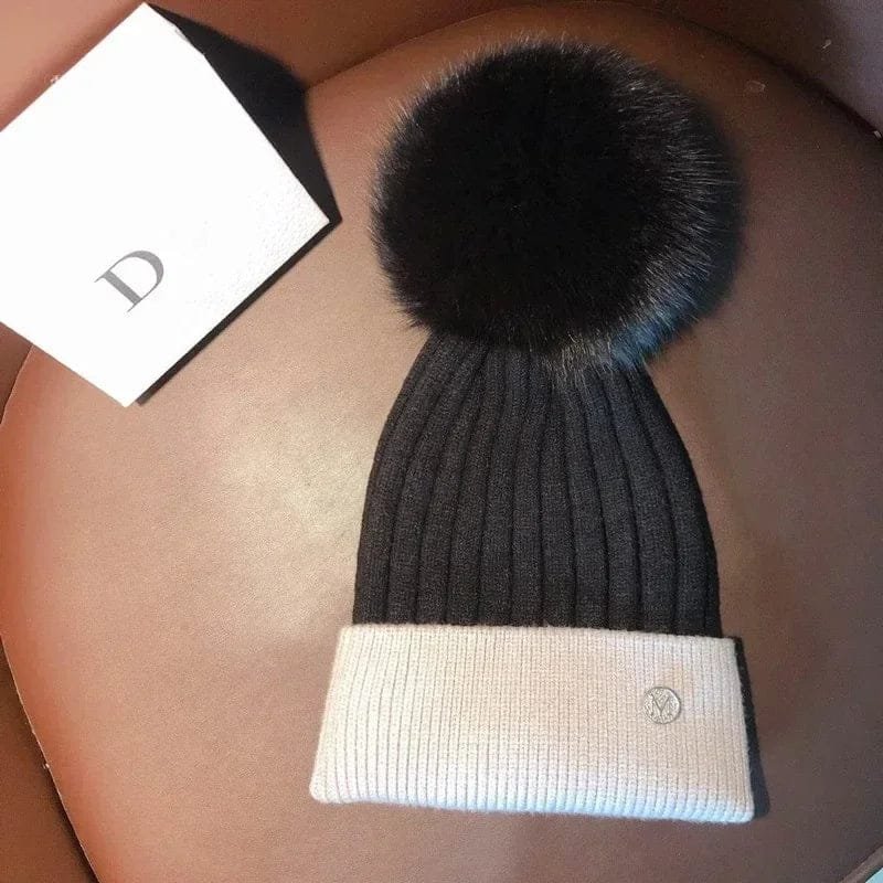 Black and white pom pom beanie flat lay as a unisex kids winter hat for daily wear and snowy play.