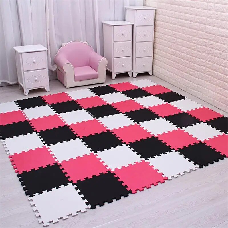 Black, white, and rose EVA foam puzzle mat used as soft flooring for kids play.