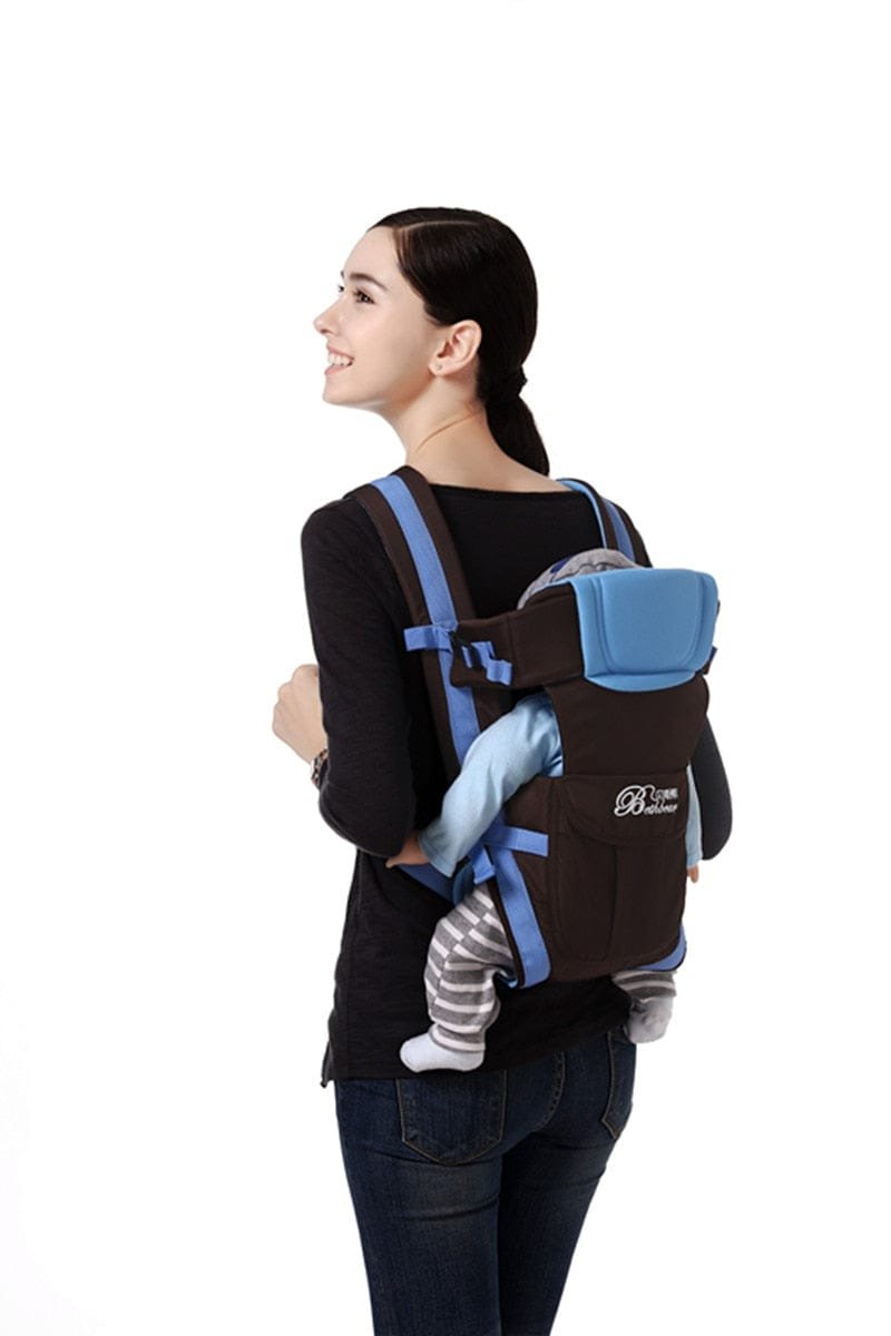 Blue and black front facing baby carrier worn by a parent for outdoor walks and hands-free care.