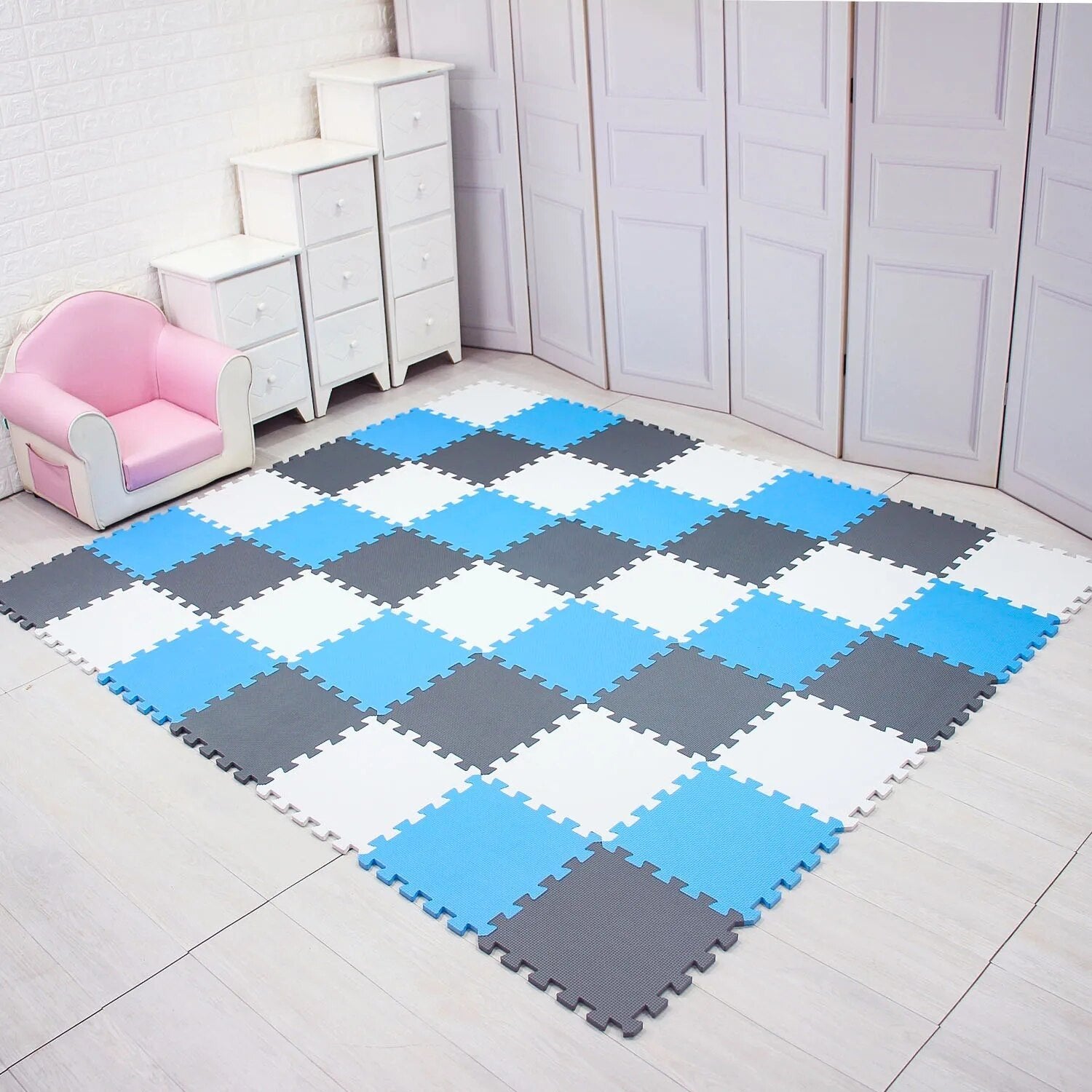 Blue, gray, and white EVA foam puzzle mat set up as a crawl space in a room corner.