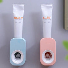 Blue and pink auto toothpaste dispensers with dust-proof covers for shared family bathroom use.