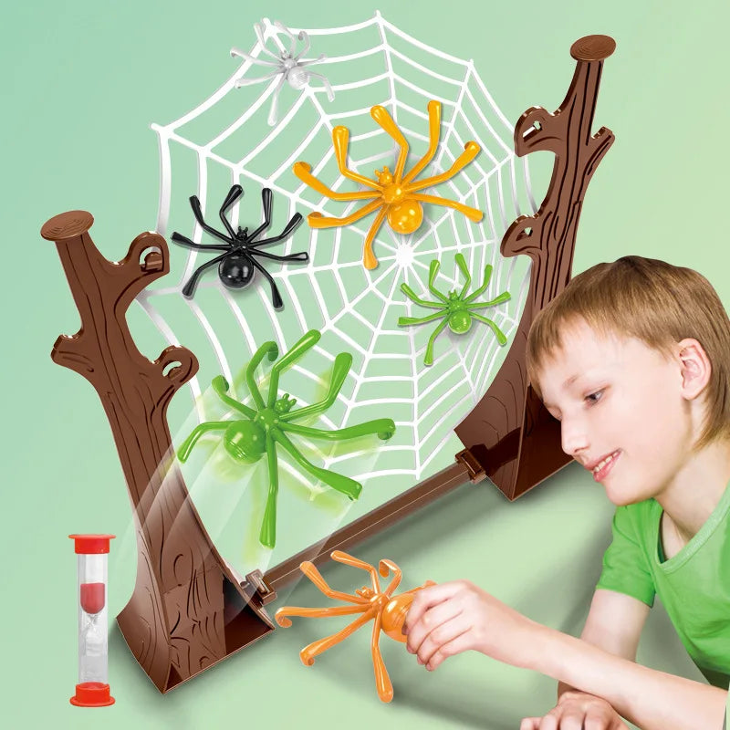 Smiling boy pressing an orange spider at the base of the web frame beside a red sand timer