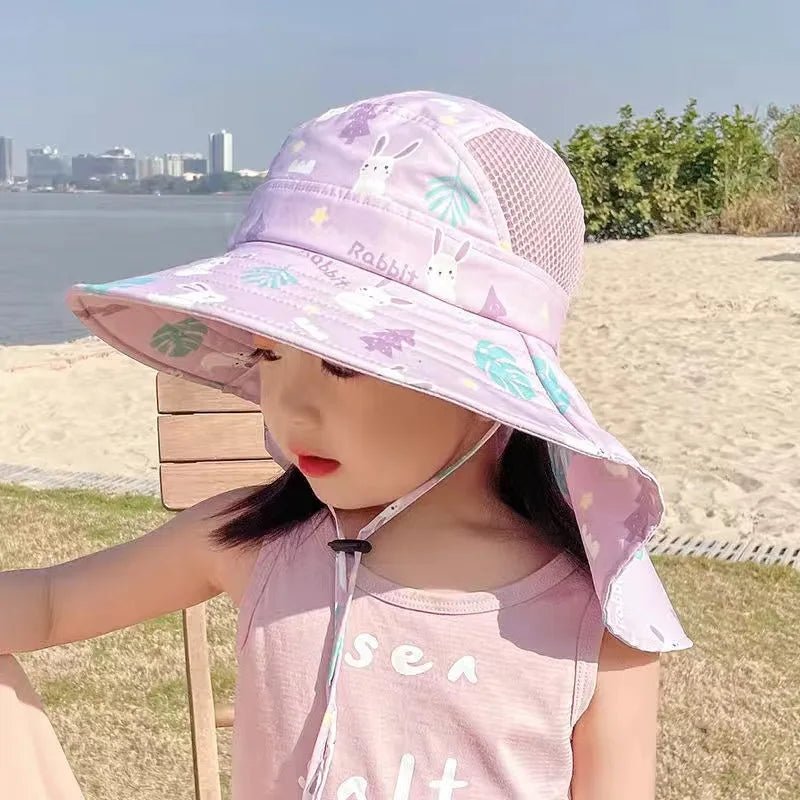 Child wearing a patterned sun hat outdoors with a scenic background