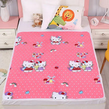 Pink cartoon-themed bedspread on a bed with colorful pillows.