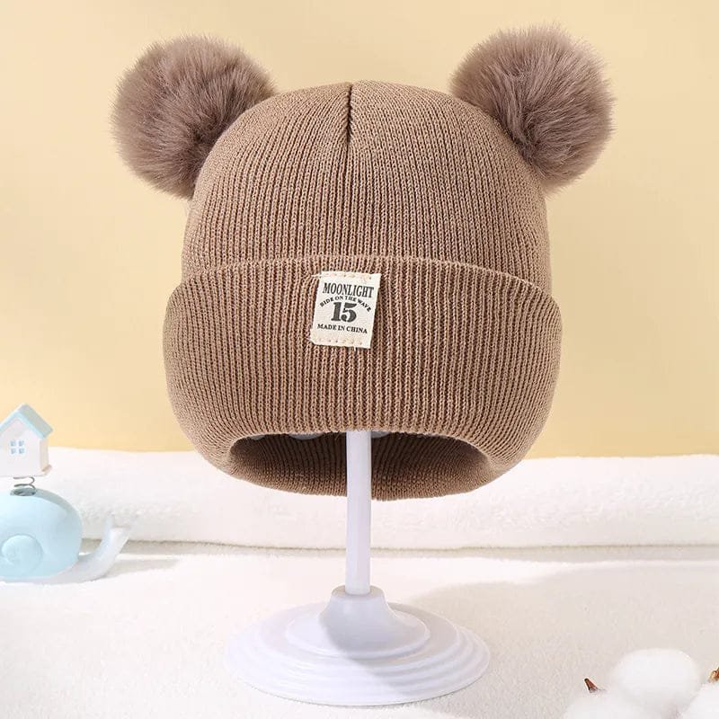 Brown Warm Knitted Baby Beanie with pom poms for keeping newborn heads warm on chilly autumn outings.
