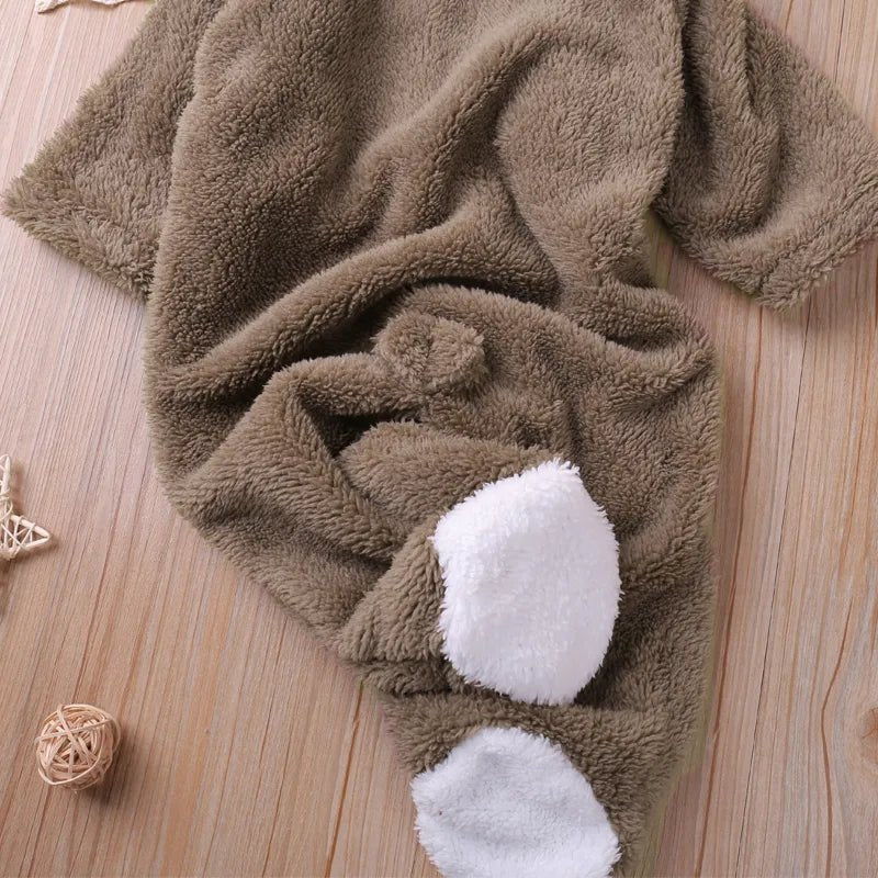 Brown plush baby romper with paw print detailing for autumn nursery days and photo sessions.