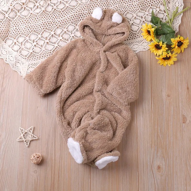 Brown teddy bear baby onesie styled with flowers for autumn photos and cosy daily wear.