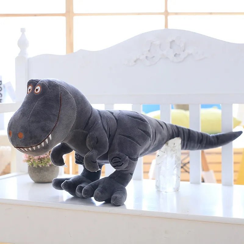 Gray plush dinosaur toy on a white surface with a blurred indoor background