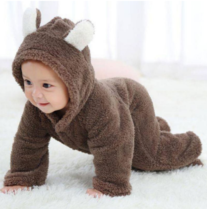 Baby in a brown animal onesie with white ears on a white background