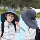 Child wearing a gray sun hat with neck flap outdoors
