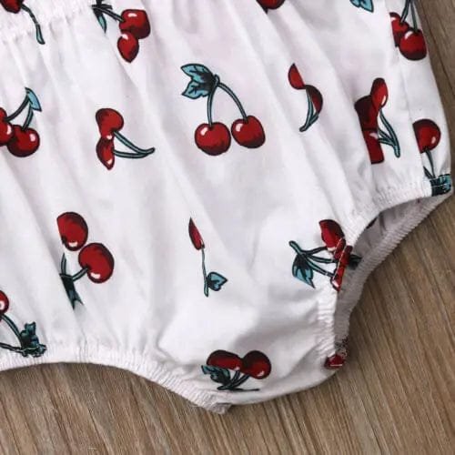 White fabric with red cherry pattern on a wooden surface