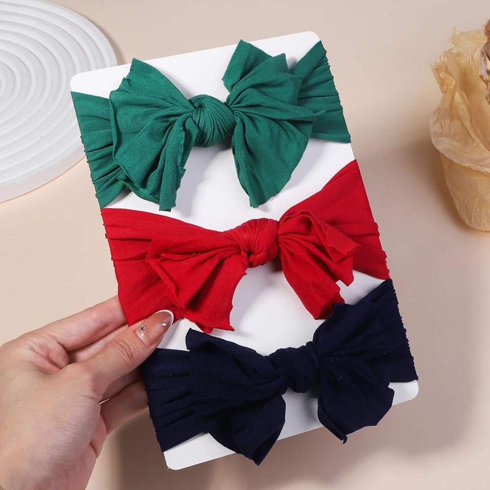Set of colorful hair bows on a white tray held by a hand 