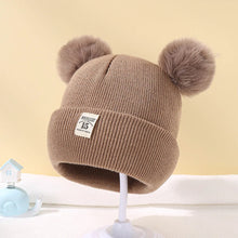Caramel Warm Knitted Baby Beanie with pom poms for cosy autumn and winter dressing and cute nursery photos.