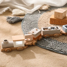 Classic Montessori wooden train and trolley toy set up on a carpeted floor for everyday indoor play.
